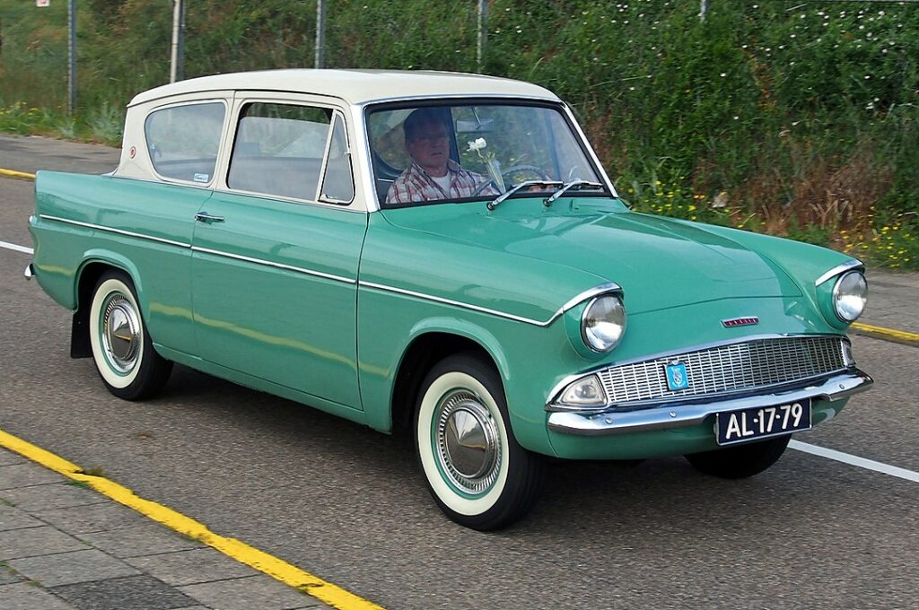 Alt="1960 Ford Anglia in green front profile on the road"